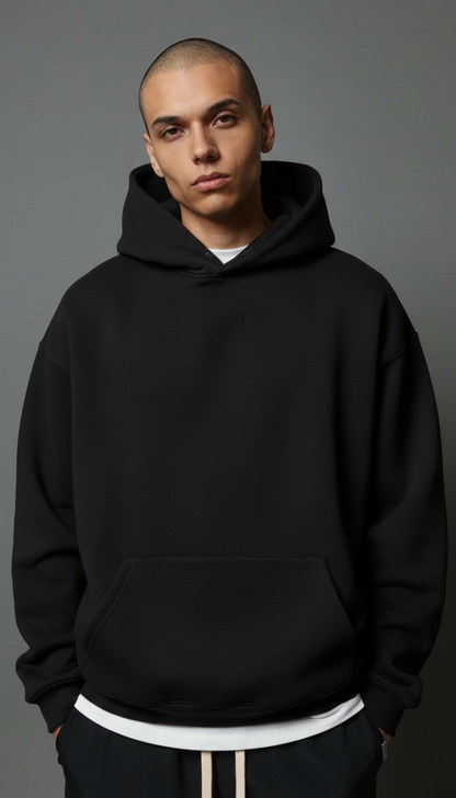 Person wearing a black hoodie against a gray background